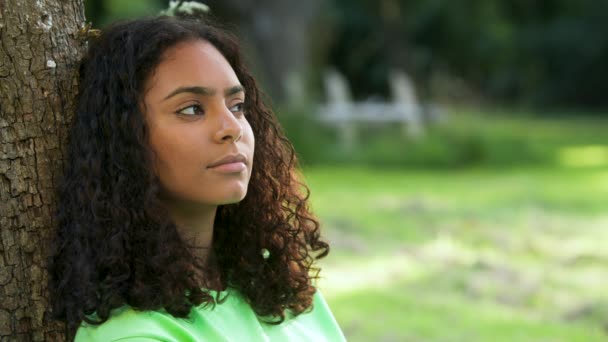 아름다운 인종인 아프리카 미국인 소녀가 나무에 기대고 슬프거나 모습으로 밖에서 — 비디오