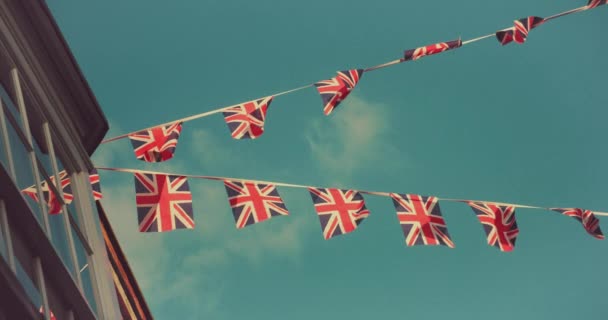 2022年夏にエリザベス女王のプラチナ ジュビリーを祝う英国の通りの家から飛んでくるユニオンジャックの旗 — ストック動画