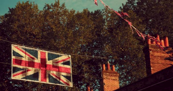 2022年夏にエリザベス女王のプラチナ ジュビリーを祝う英国の通りの家から飛んでくるユニオンジャックの旗 — ストック動画