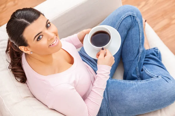 Beautiful young Latina Hispanic girl female young woman at home relaxing with a cup of tea or coffee.