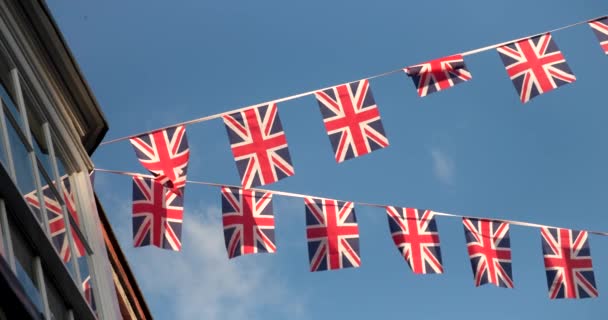 Флаги Юнион Джек Вылетающие Домов Улицах Англии Великобритании Против Голубого — стоковое видео