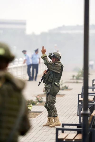 Soldado en uniforme militar con pistola muestra gesto de mano al resto de soldados Fotos de stock