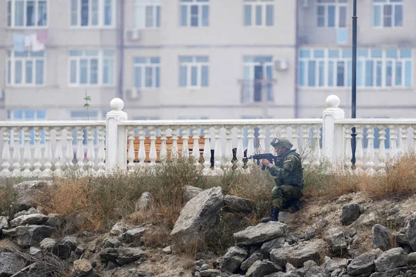 Soldado en uniforme militar se sienta en refugio detrás de valla de piedra blanca Fotos de stock