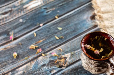 Masaya saçılmış çay yaprakları ve bir fincan çay.