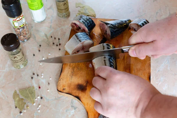 Tuzlamak için balıkları parçalara ayırıyor.