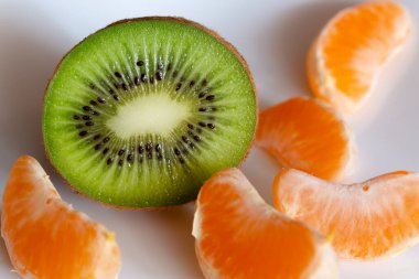Beyaz arka planda Kivi ve Mandarin dilimleri