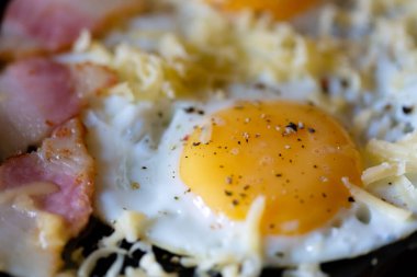 Domuz pastırmalı ve peynirli sahanda yumurta.