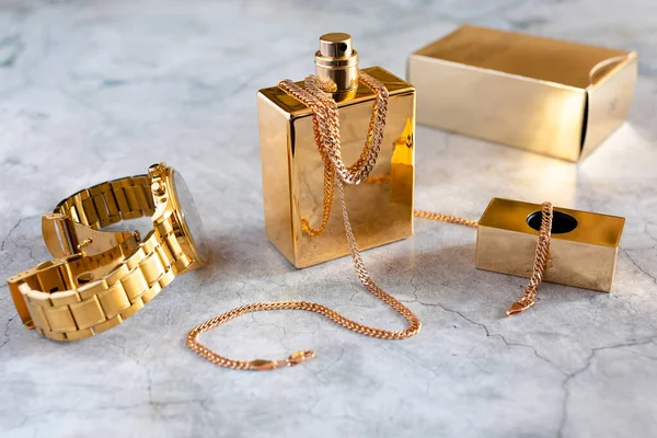 Erkek parfümü ve beton arka planda saatler.