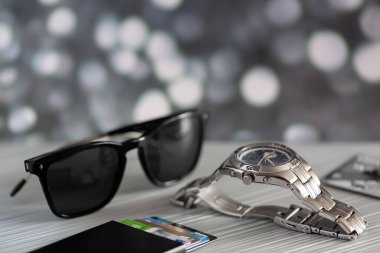 Kol saati ve siyah gözlükler masanın üstünde.