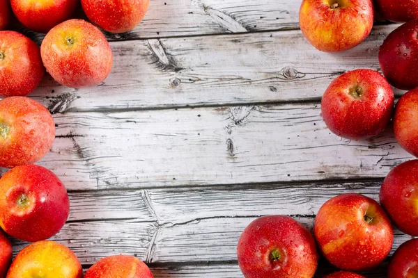 Ahşap bir arka planda kırmızı elmaları yıkadım.