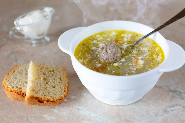 Masada ekşi kremalı bir tabak sıcak çorba