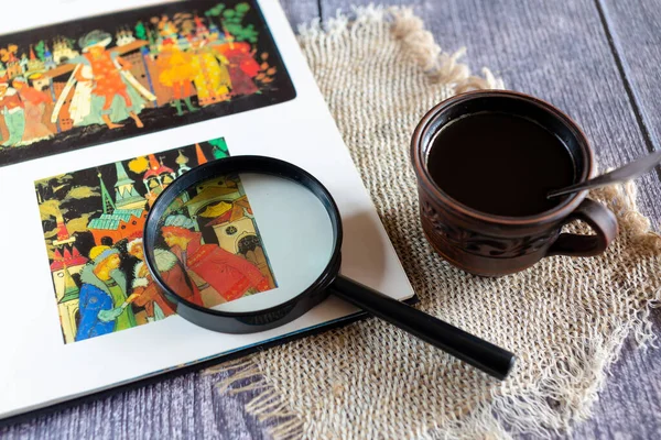 İçinde illüstrasyon ve bir fincan kahve olan açık bir kitap.