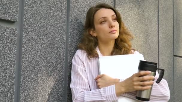 Vrouwelijke portret van jonge vrouw met zilveren laptop en kopje koffie te wachten op een vergadering in de buurt van donkergrijze muur in de ochtend, afgelegen baan, koffiepauze, slimme student concept — Stockvideo