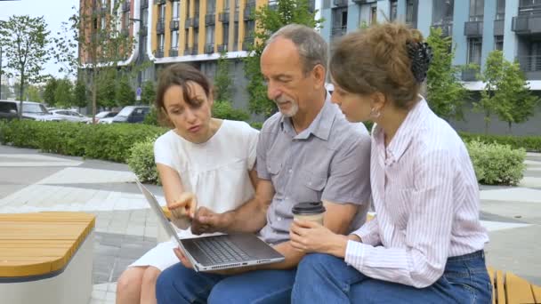 Senior Business Mentor oder Coach unterrichtet Praktikanten, zeigt auf den Laptop-Bildschirm, hilft neuen Mitarbeitern mit Unternehmenssoftware, gibt Anweisungen, Kollegen arbeiten zusammen — Stockvideo