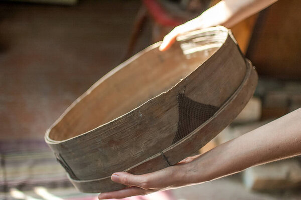 Old sieves, tool for bakery from the past for flour sifting in female hands