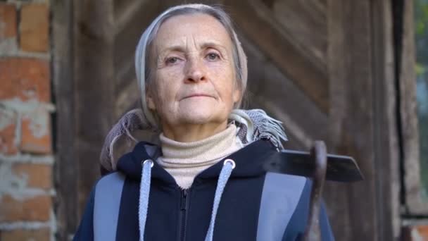 Ευτυχισμένη όμορφη ηλικιωμένη γυναίκα κρατά μεταλλικό σκαλιστήρι και το κάνει καθαρό μετά τη δουλειά και βοτάνισμα στον κήπο, ευτυχισμένη συνταξιοδότηση — Αρχείο Βίντεο