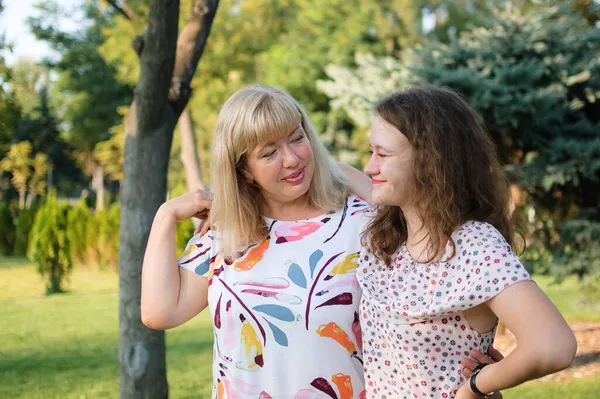 Retrato femenino de una hermosa madre rubia de ojos azules y tamaño grande en el parque durante el verano. Día de la familia, concepto de gente feliz —  Fotos de Stock