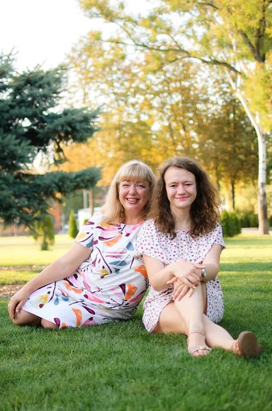 Retrato femenino de una hermosa madre rubia de ojos azules y tamaño grande en el parque durante el verano. Día de la familia, concepto de gente feliz — Foto de Stock