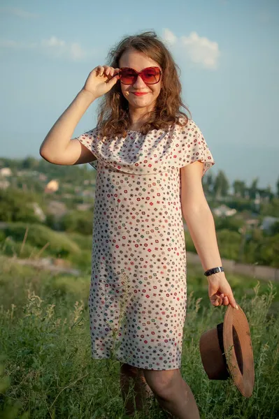 Chica joven en vestido está teniendo un gran momento durante las vacaciones en el verano en el fondo del cielo en la naturaleza, concepto de viaje —  Fotos de Stock