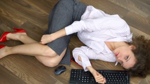Manajer kantor perempuan muda lelah berbaring di lantai dengan keyboard, mouse dan smartphone, gerakan rata berbaring, pekerjaan rutin, freelance, sindrom burnout — Stok Video