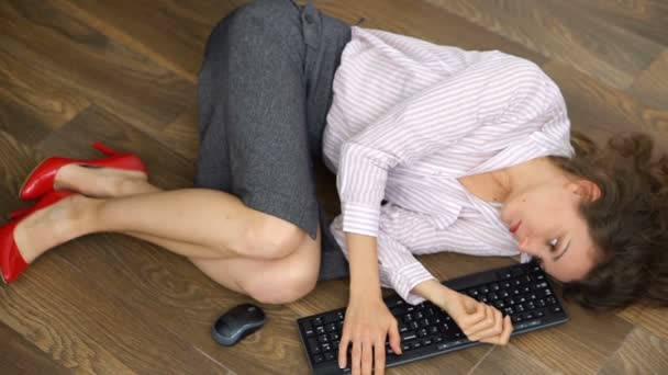 Усталая молодая женщина офис-менеджер лежит на полу с клавиатурой, мышью и смартфоном, лежал плоское движение, рутинная работа, фриланс, синдром выгорания — стоковое видео