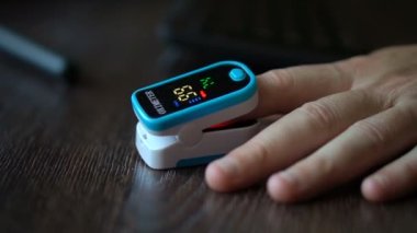Erkek hastalarda nabız oksimetresi koyu ahşap masa geçmişi, tıbbi ekipmanlar, taşınabilir oksitmetre, zatürree önleme, covid-19 salgın sonuçları üzerine parmak ucu.