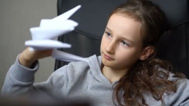 Küçük sarışın kız origamiyle oynuyor, ejderha pençeleri, kağıt ejderhalar yaratımı, çocuk sanatı konsepti..