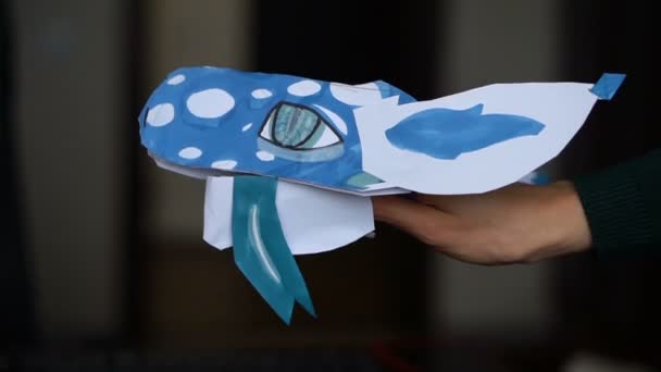 Blå origami drake med lång tunga i barnhänder, papper drakar skapande, barn konst koncept. — Stockvideo