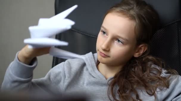 Gadis pirang kecil bermain dengan origami, cakar kertas naga, penciptaan naga kertas, konsep seni anak-anak. — Stok Video