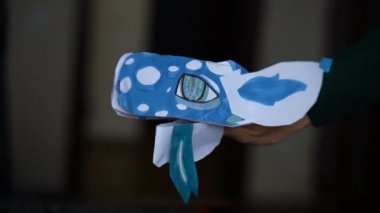 Mavi origami ejderhası uzun dilli çocuk ellerinde, kağıt ejderhalar yaratıyor, çocuk sanatı kavramı.