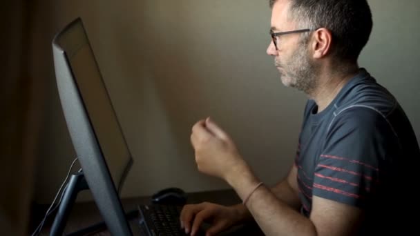 Senior man werkt achter de computer, zakenman gebruikt grote monitor aan tafel, account manager werkt, remote job — Stockvideo