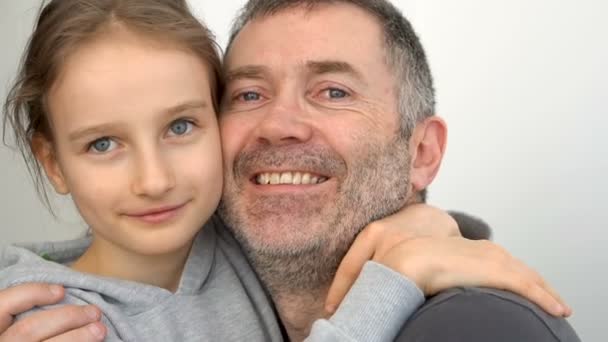 Familie portret van senior vader en kleine blonde dochters knuffelen binnen en glimlachen, vaders dag viering concept — Stockvideo