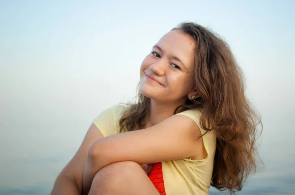 Молода дівчина в жовтій футболці на морському і блакитному фоні неба, літній час, подорожі, жіночий портрет концепції — стокове фото