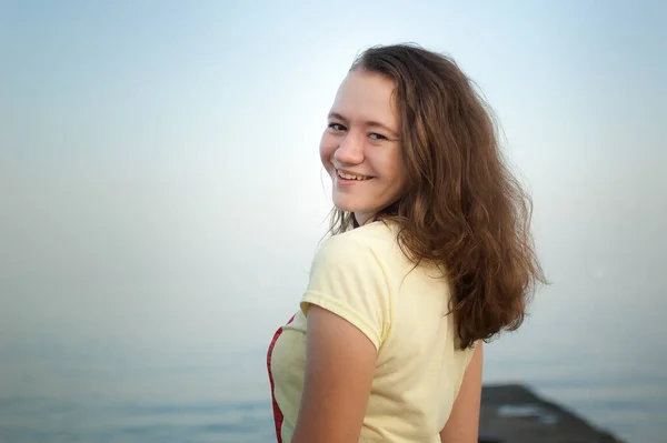 Молода дівчина в жовтій футболці на морському і блакитному фоні неба, літній час, подорожі, жіночий портрет концепції — стокове фото