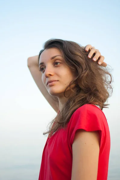 Молодая девушка в красном платье на море и синем фоне, летом, путешествующие концепции — стоковое фото