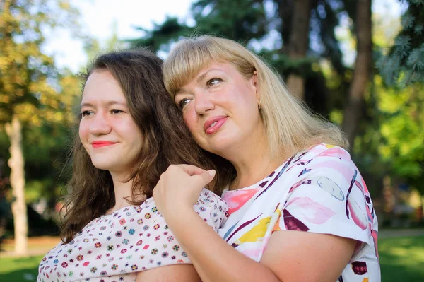 Retrato femenino de una hermosa madre rubia de ojos azules y tamaño grande en el parque durante el verano. Día de la familia, concepto de gente feliz — Foto de Stock