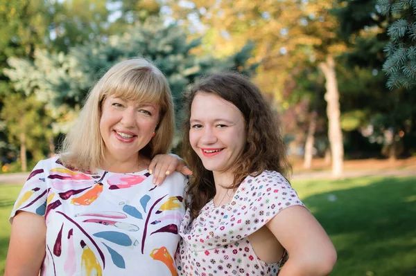 Retrato femenino de una hermosa madre rubia de ojos azules y tamaño grande en el parque durante el verano. Día de la familia, concepto de gente feliz —  Fotos de Stock