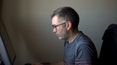 Kıdemli adam bilgisayarın önünde çalışıyor, işadamı büyük monitör kullanıyor masada oturuyor, hesap yöneticisi çalışıyor, uzaktan kumanda ediliyor.