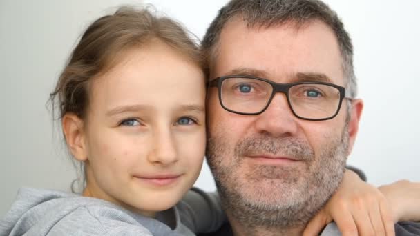 Rodinný portrét staršího otce a malých blonďatých dcer se objímají v interiéru a usmívají se, oslavy otců — Stock video