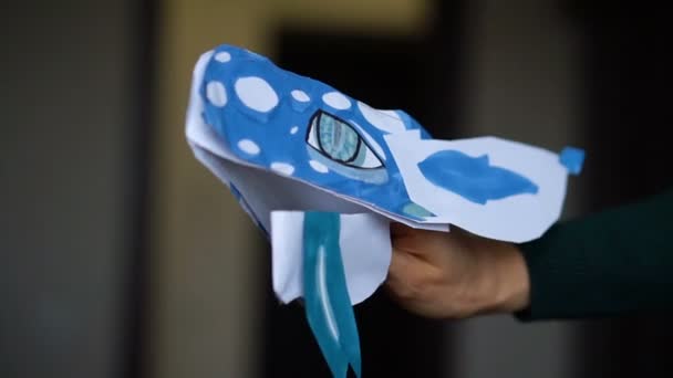 Blå origami drake med lång tunga i barnhänder, papper drakar skapande, barn konst koncept. — Stockvideo