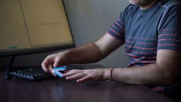 Pulsoximeter eines männlichen Patienten Fingerkuppe auf dunklem Holztischhintergrund, medizinische Geräte, tragbares Oximeter, Lungenentzündungsprophylaxe, Covid-19 pandemische Folgen — Stockvideo