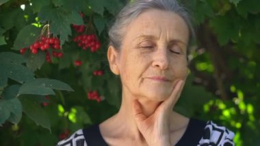 Üzgün, olgun bir kadının yakın plan portresi. Pişman olduğu bir şey için ellerini başının yakınında tutuyor. Negatif duygu, yüz ifadesi, his