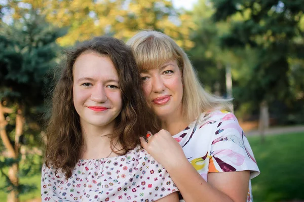 Retrato feminino de uma linda mãe e filha loira e de olhos azuis no parque durante o verão. Dia da família, conceito de pessoas felizes — Fotografia de Stock