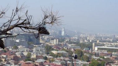 Gürcistan 'ın Tiflis şehrinin üzerinde asılı duran Cableway otomobili arka plandaki eski binalar, seyahat ve turizm kavramlarıyla