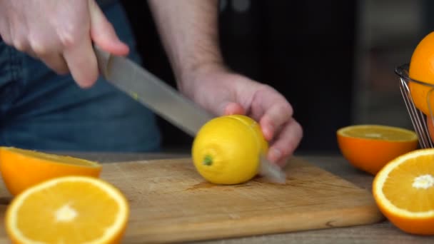 Mannelijke handen snijden rijpe citroen voor het maken van citrussap, gezonde levensstijl, vruchtensap — Stockvideo