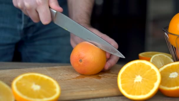 Mãos masculinas estão cortando toranja madura para fazer suco cítrico, estilo de vida saudável, suco de frutas — Vídeo de Stock
