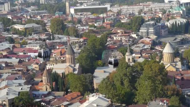 Linbanevagn hänger ovanför staden Tbilisi i Georgien med utsikt över gamla byggnader på bakgrund, resor och turism koncept — Stockvideo