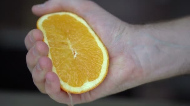 한 남자가 감귤 즙을 가지고 오렌지 주스 를 짜고 있다. 손을 감는 일, 오렌지, 주스, 건강 한 생활 — 비디오