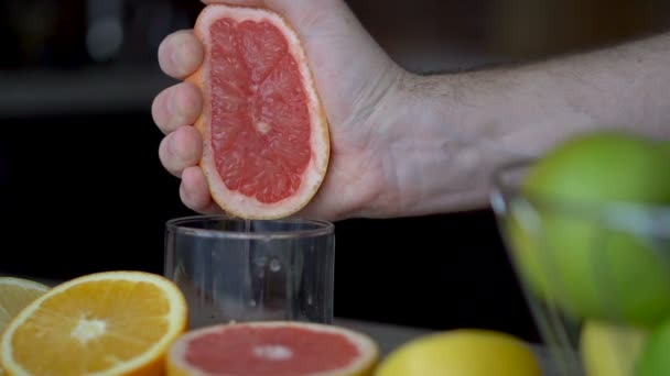 Mãos masculinas estão apertando toranja madura para fazer suco cítrico, estilo de vida saudável, suco de frutas — Vídeo de Stock