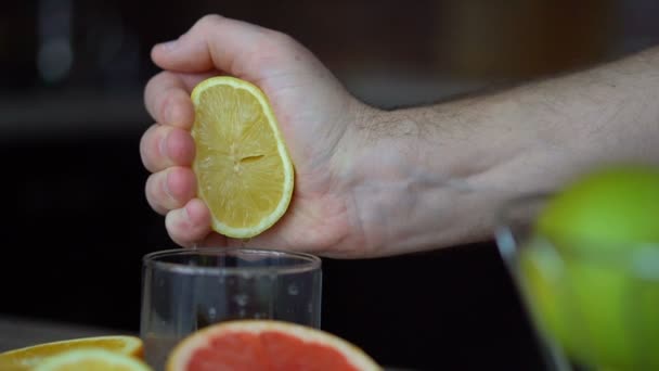 Mannelijke handen knijpen rijpe citroen voor het maken van citrussap, gezonde levensstijl, vruchtensap — Stockvideo